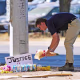 A man places flowers near the site where a Venezuelan man was shot in his vehicle by an ICE officer in Austin, Texas.