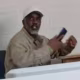 Diddy seated at a table holding a cellphone