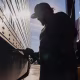 A semi truck driver refuels a truck.