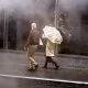 People walk in a street as the rains pours.
