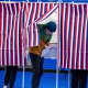A person exits a voting booth after filling out their ballot.