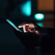 Image: Close-up of a man using a touchscreen phone.