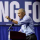 Former President Obama standing at a lectern during a political rally.