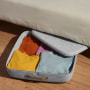 Illustration of grey underbed storage filled with clothes and a stack of 2 bins from Get Open Spaces