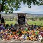 Image:  A makeshift memorial honoring the 215 children whose remains have been discovered buried near the facility surrounds a monument outside the former Kamloops Indian Residential School in Kamloops, British Columbia, Canada, on June 2, 2021.