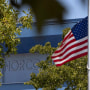 Image: The American flag flies at half-mast outside the high school of Marine Corps Lance Corporal Kareem Nikoui High School following his death in Afghanistan