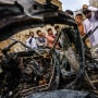 Image: Relatives and neighbors of the Ahmadi family gathered around the incinerated husk of a vehicle in Kabul, Afghanistan, on August 30, 2021.