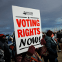Image: People hold a sign that reads, \"Voting Rights Now\" on Jan. 17, 2022 while celebrating Martin Luther King day in Washington.