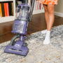 Woman using a vacuum on a carpet