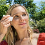 Woman putting sunscreen on her face