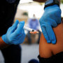 A healthcare worker from the El Paso Fire Department administers a Moderna Covid-19 vaccination near the Santa Fe International Bridge in El Paso, Texas, on May 7, 2021.