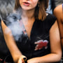 Two women smoke cannabis vape pens at a party in Los Angeles on June 8, 2019
