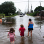 A mother and her children through flood waters after Hurricane Nicholas landed in Galveston, Texas, on Sept. 14, 2021.