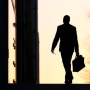 FILE PHOTO: A worker arrives at his office in the Canary Wharf business district in London