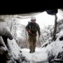 A Ukrainian Military Forces serviceman walks along a snow covered trench on the frontline with the Russia-backed separatists near Zolote village, in the eastern Lugansk region, on Jan. 21, 2022.
