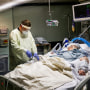 Medical staff treat a Covid-19 patient in their isolation room on the Intensive Care Unit at Western Reserve Hospital in Cuyahoga Falls, Ohio, on Jan. 5, 2022.