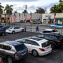 Image: A pedestrian walks past a pre-owned car sales lot in Miami on Jan. 12, 2022.