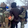 Police officers detain a man outside a munitions facility in the central Ukrainian city of Dnipro, after five were reportedly shot dead on Thursday morning.
