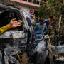 Image: Relatives and neighbors of the Ahmadi family gather around the incinerated husk of a vehicle targeted and hit by an U.S. drone strike that was supposed to target ISIS-K suicide bombers but instead killed civilians in Kabul, Afghanistan on Aug. 30, 2021.