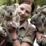 Image: Wildlife officer poses with koalas