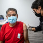 Irene Michel, right, gives Jaime Sores, 70, left, a Covid-19 vaccination booster at a Covid-19 vaccine clinic on Nov. 17, 2021 in El Monte, Calif.