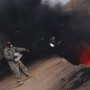 Image: An equipment manager tosses unserviceable uniform items into a burn pit in Iraq on March 10, 2008.