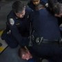 Edward Bronstein is held down by CHP officers.