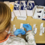 Image: Healthcare workers inside a test room at a Covid-19 drive-thru testing site in Sumter, S.C. , on Jan. 13, 2022.