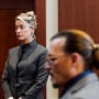 Amber Heard and Johnny Depp watch as the jury leave the courtroom for a lunch break at the Fairfax County Circuit Courthouse in Fairfax, Va., on May 16, 2022.