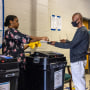 A poll worker assists a voter at Corley Elementary School in Gwinnett County in Buford, Ga., on May 24, 2022.