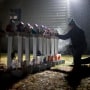 Frank Kulick, adjusts a display of wooden crosses, and a Jewish Star of David, representing the victims of the Sandy Hook Elementary School shooting, on his front lawn on Dec. 17, 2012, in Newtown, Conn.