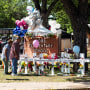 People stand looking at a memorial at Robb Elementary School following a mass shooting on May 26, 2022 in Uvalde, Texas.
