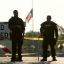 Two police officers stand their post on July 5, 2022, the day after a mass shooting in Highland Park, Ill.