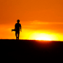 A skateboarder walks through a park at sunset on June 8, 2022, in San Antonio, as temperatures in South Texas continued to top the 100 degree mark.