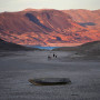 People walk towards a formerly sunken boat on cracked earth hundreds of feet from what is now the shoreline on Lake Mead at the Lake Mead National Recreation Area, near Boulder City, Nev., on May 9, 2022.