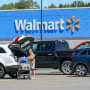 A woman loads groceries into her car at a Walmart