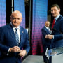 Arizona Democratic Sen. Mark Kelly, left, Republican challenger Blake Masters, right, and Libertarian Marc Victor, back, pause on the stage prior to a televised debate in Phoenix, Thursday, Oct. 6, 2022.