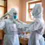 Image: Doctors put on protective equipment as they prepare to visit a patient who was in contact with an Ebola victim, in the isolation section of Entebbe Regional Referral Hospital in Entebbe, Uganda on Oct. 20, 2022.