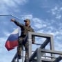 Un miembro de las tropas ucranianas derriba una bandera de la República de Donetsk, izada en un monumento en Lyman, Ucrania, en esta captura de pantalla obtenida de un vídeo de las redes sociales publicado el 1 de octubre de 2022.