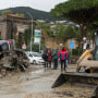 Rescuers remove mud from a street after landslides in Casamicciola, Italy