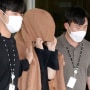 A woman, center, leaves to the Seoul Central District Prosecutors' Office at Ulsan Jungbu police station in Ulsan, South Korea, on Sept. 15, 2022. A South Korean court has approved the extradition of the 42-year-old woman facing murder charges in New Zealand over her possible connection to the bodies of two long-dead children found abandoned in suitcases in August. The Seoul High Court said Friday, Nov. 11, its decision came after the unidentified woman agreed to be sent back to New Zealand.