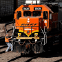 A worker boards a locomotive at a BNSF rail yard, in Kansas City