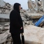 A man stands next to the rubble of a building in Zardana, Syria