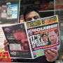 A newspaper vendor displays a copy of the National Enquirer at his newstand in New York