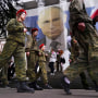 Russian cadets mark the 9 year annexation of Crimea as they pass a banner showing President Vladimir Putin in Yalta, Crimea on March 17, 2023.