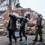 Volunteers carry remains of a Uragan rocket after a monastery was destroyed in a shelling in Dolyna, Ukraine