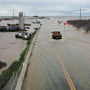 A truck drives across a flooded road near Corcoran, Calif.