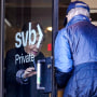 Image: People enter and depart a Silicon Valley Bank branch location in Wellesley, Mass., on March 27, 2023. 