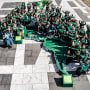 Una veintena de mujeres sostienen un pañuelo verde, el símbolo latinoamericano del movimiento por el derecho al aborto, formando entre ellas una estructura como la del mapa de las Américas