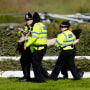 Members of the police forces remove a protester before the start of a Grand National horse race